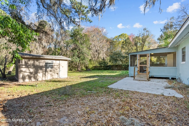 view of yard with an outdoor structure, a patio area, fence, and a sunroom