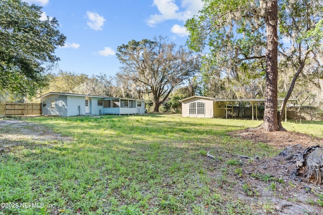 view of yard featuring fence and an outbuilding