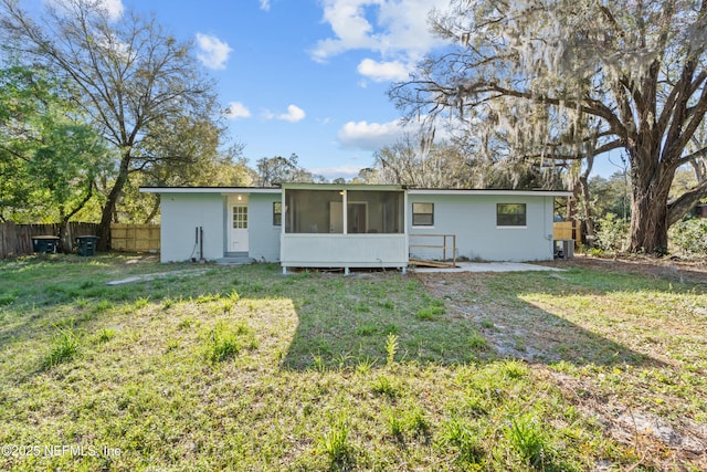 rear view of house with a sunroom, a lawn, fence, and central AC