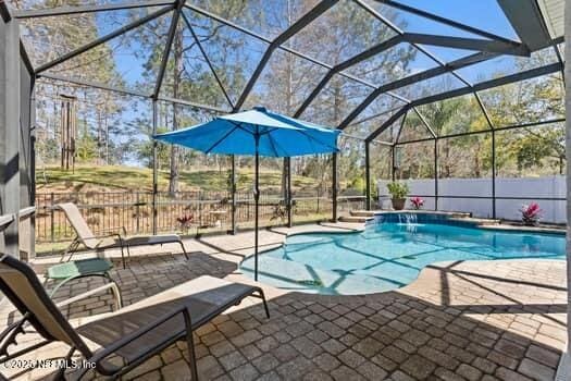 view of swimming pool with a patio area, a lanai, a fenced in pool, and fence