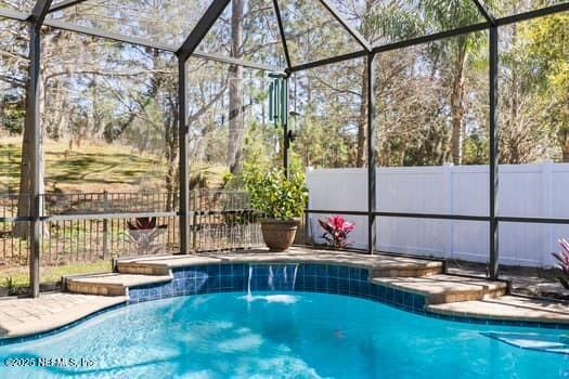 view of pool featuring fence, a fenced in pool, and a lanai