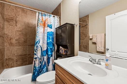 bathroom featuring shower / tub combo, a textured ceiling, toilet, and vanity