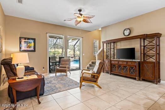 living area featuring a ceiling fan, a sunroom, visible vents, and light tile patterned flooring