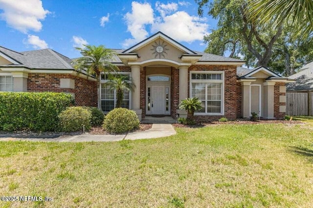 view of front of home with a front lawn and brick siding