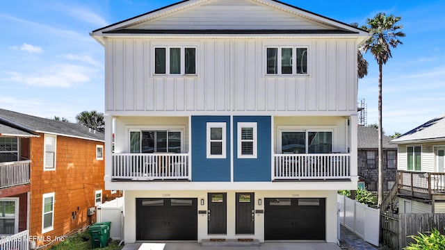 coastal home featuring a garage, fence, and board and batten siding