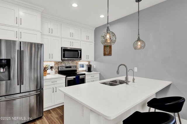 1306 1st St S, Jacksonville Beach, FL 32250 - kitchen with a breakfast bar area, decorative backsplash, appliances with stainless steel finishes, wood finished floors, and a sink