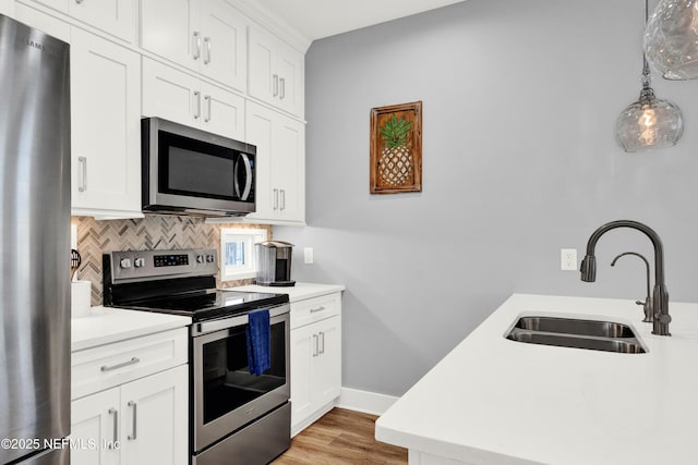 1306 1st St S, Jacksonville Beach, FL 32250 - kitchen with tasteful backsplash, light countertops, light wood-style flooring, appliances with stainless steel finishes, and a sink