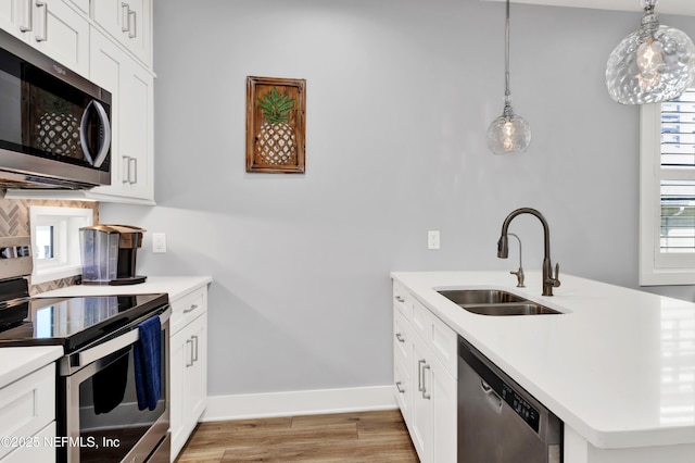 1306 1st St S, Jacksonville Beach, FL 32250 - kitchen featuring baseboards, a peninsula, a sink, stainless steel appliances, and light countertops