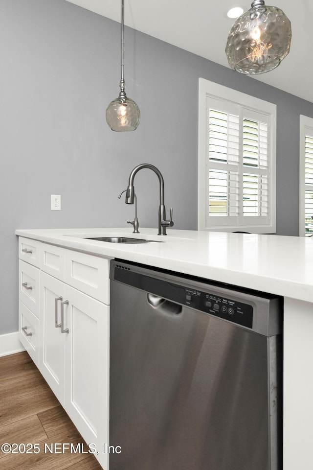 1306 1st St S, Jacksonville Beach, FL 32250 - kitchen with pendant lighting, light countertops, stainless steel dishwasher, wood finished floors, and a sink