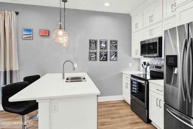 1308 1st St S, Jacksonville Beach, FL 32250 - kitchen with light countertops, a breakfast bar area, a sink, light wood-style flooring, and appliances with stainless steel finishes