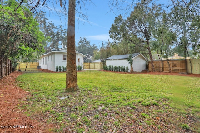 view of yard with an outdoor structure and a fenced backyard