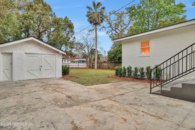 view of yard featuring an outbuilding, fence, and stairway