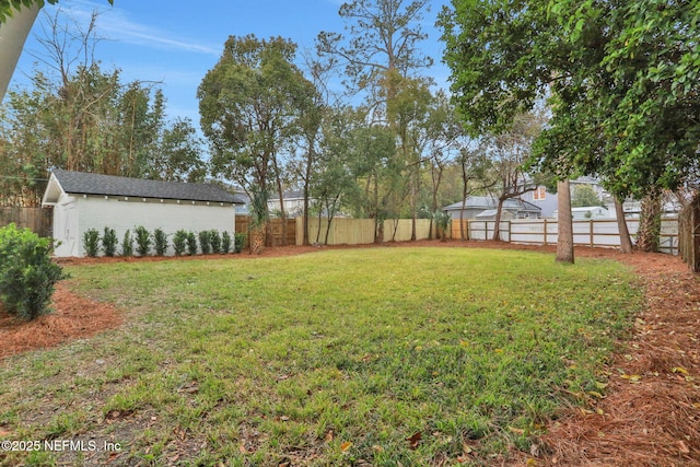 view of yard featuring a fenced backyard and an outbuilding