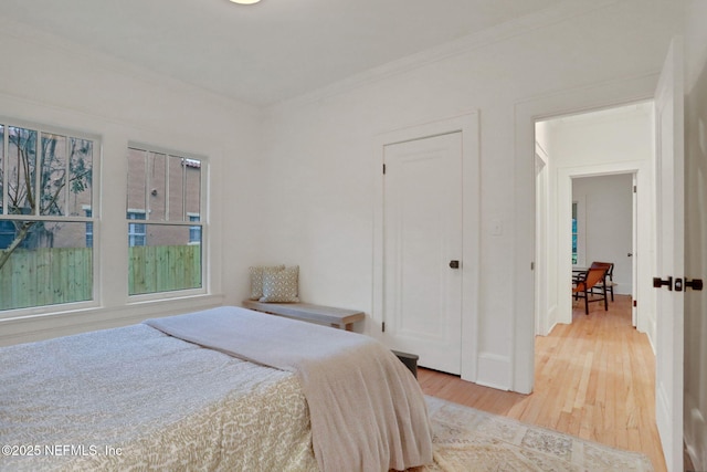 bedroom featuring ornamental molding and light wood-type flooring