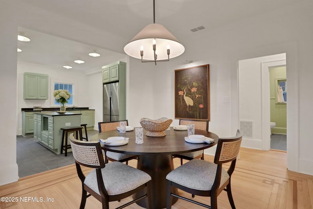 dining area featuring visible vents and wood finished floors