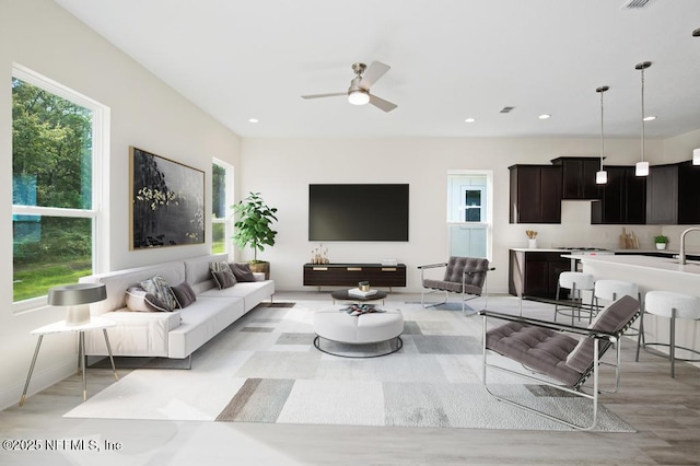 living room featuring a ceiling fan, light wood-style flooring, and recessed lighting