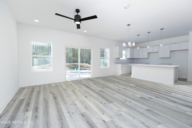 unfurnished living room featuring recessed lighting, a healthy amount of sunlight, and light wood-style floors