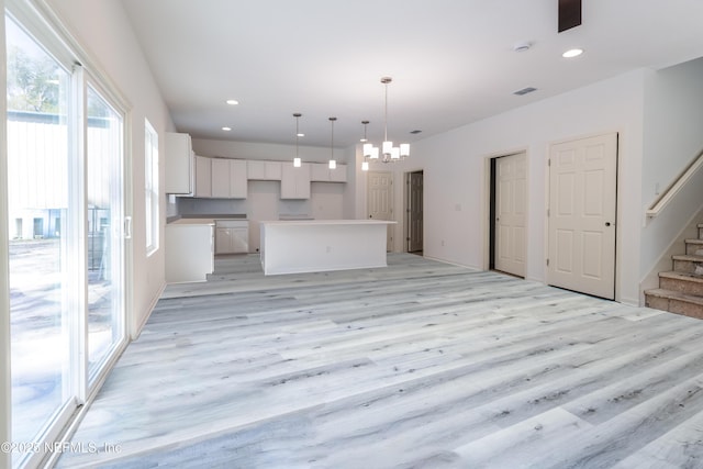 kitchen featuring recessed lighting, light wood-type flooring, an inviting chandelier, and white cabinetry