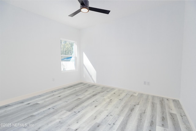 empty room with a ceiling fan, baseboards, and light wood finished floors