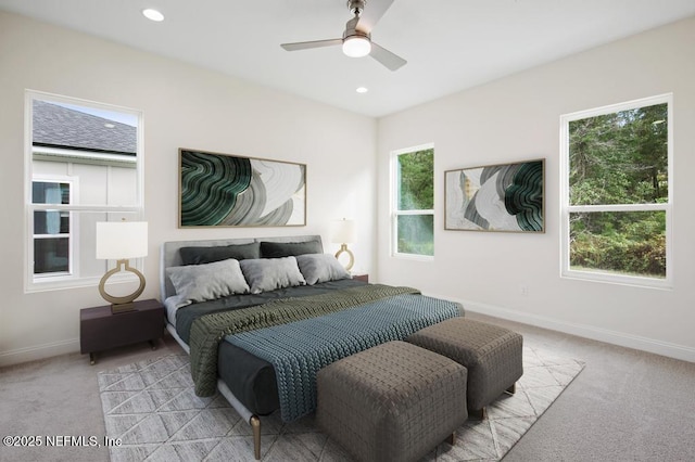 bedroom featuring light colored carpet, baseboards, and multiple windows