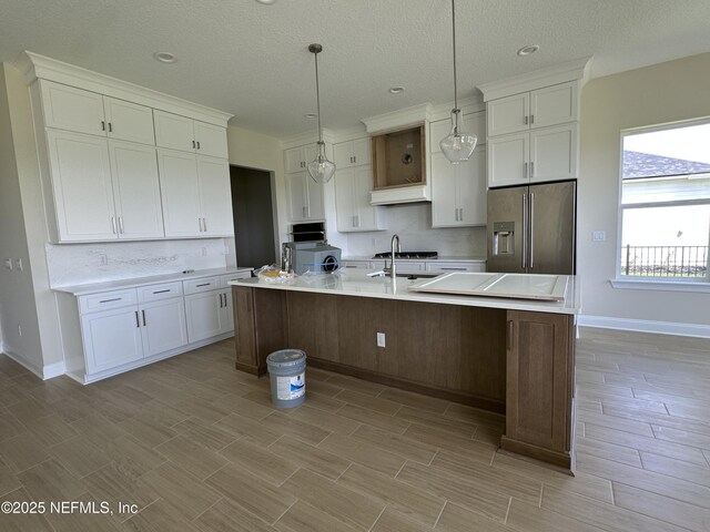 123 Tesoro Ter, Saint Augustine, FL 32095 - kitchen featuring high end refrigerator, tasteful backsplash, white cabinetry, light countertops, and a textured ceiling