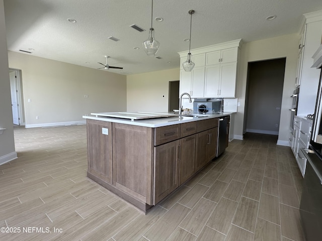 123 Tesoro Ter, Saint Augustine, FL 32095 - kitchen featuring wood tiled floors, dishwasher, light countertops, white cabinetry, and a center island with sink