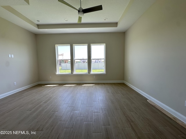 123 Tesoro Ter, Saint Augustine, FL 32095 - empty room featuring a tray ceiling, dark wood-type flooring, and a ceiling fan