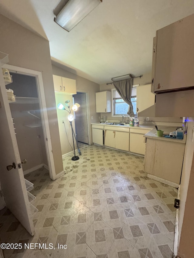 kitchen with lofted ceiling, light countertops, and a sink