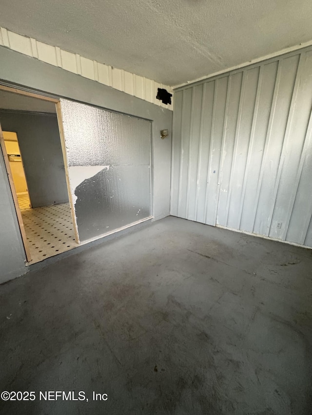 spare room with concrete floors and a textured ceiling