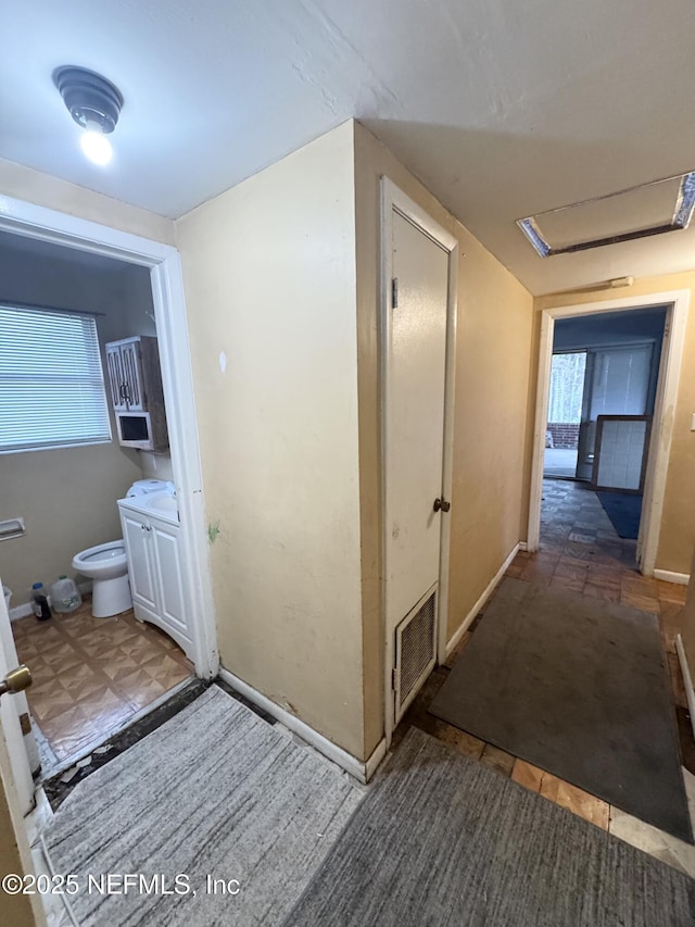 hallway with visible vents and baseboards