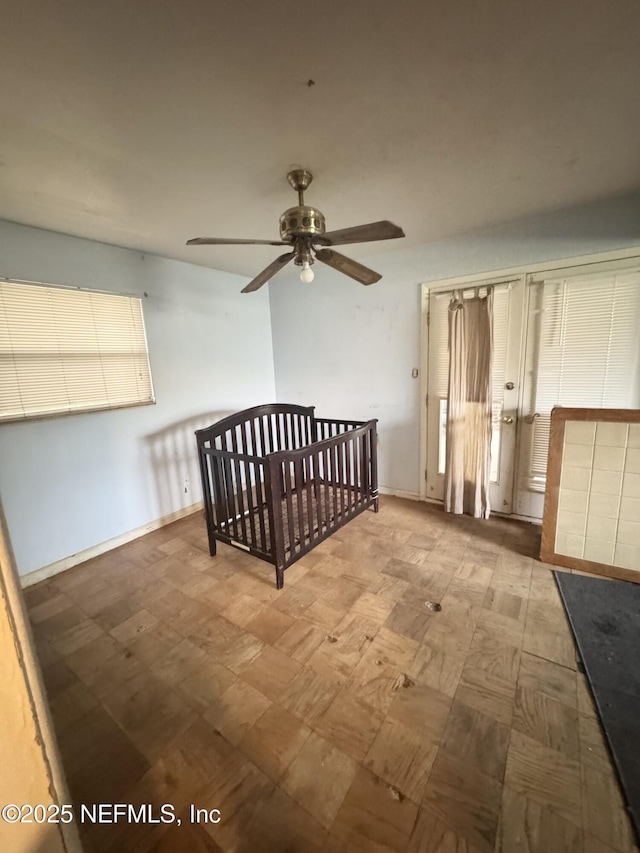 interior space featuring ceiling fan, tile patterned floors, and baseboards