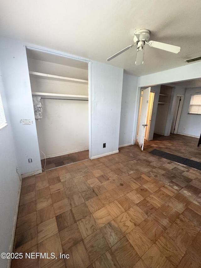 unfurnished bedroom with baseboards, visible vents, and ceiling fan