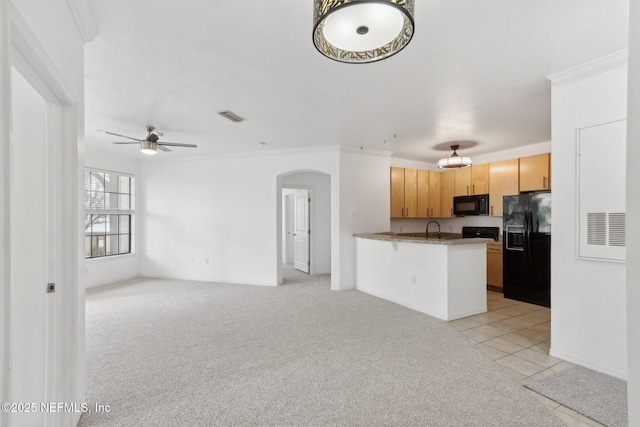 kitchen featuring visible vents, light carpet, black appliances, arched walkways, and a peninsula