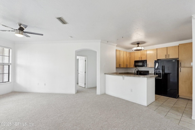 kitchen featuring black appliances, open floor plan, arched walkways, a peninsula, and light colored carpet