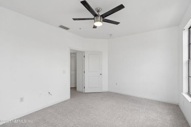 spare room featuring visible vents, carpet floors, baseboards, and a ceiling fan