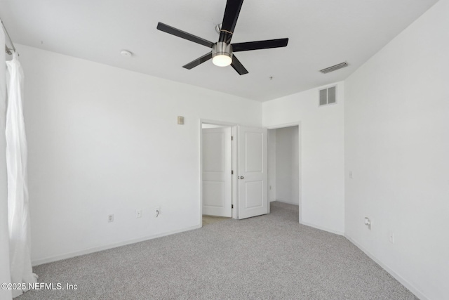 unfurnished bedroom featuring a ceiling fan, light colored carpet, visible vents, and baseboards