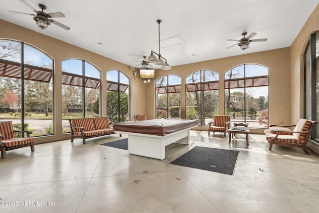 sunroom with a ceiling fan and a healthy amount of sunlight