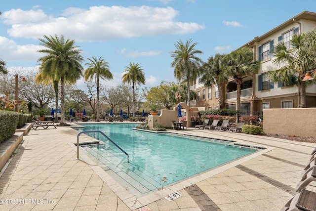 community pool featuring a patio and fence