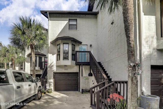 exterior space featuring stairs, brick siding, cooling unit, and a garage