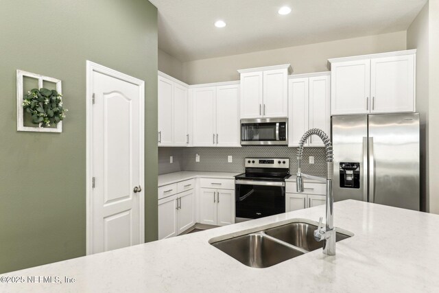 kitchen featuring appliances with stainless steel finishes, backsplash, and white cabinetry