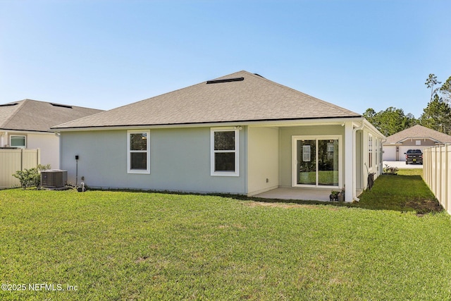 rear view of house with fence private yard, cooling unit, a shingled roof, a yard, and stucco siding