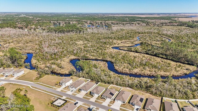 birds eye view of property with a water view, a residential view, and a wooded view