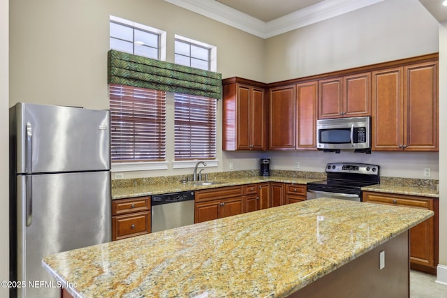 kitchen with light stone counters, a center island, crown molding, stainless steel appliances, and a sink