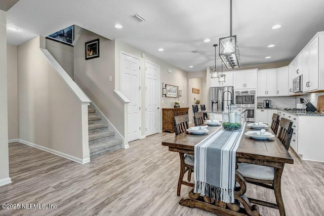 6743 Summit Vista Ct, Jacksonville, FL 32259 - dining room with visible vents, light wood-style flooring, baseboards, and stairs