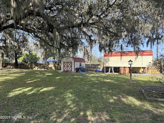 view of yard with a storage unit, a fenced backyard, and an outdoor structure