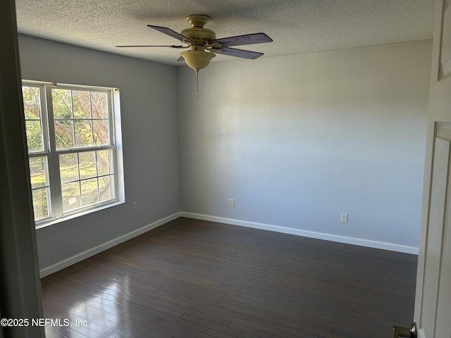 empty room with dark wood finished floors, a textured ceiling, baseboards, and ceiling fan