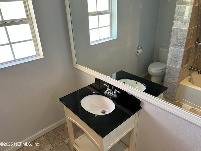 bathroom with baseboards, toilet, bathtub / shower combination, and vanity