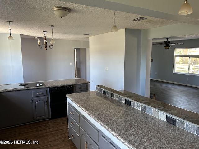 kitchen featuring dark wood-type flooring, decorative light fixtures, black dishwasher, and a textured ceiling