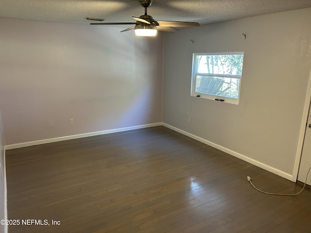 spare room with dark wood finished floors, a textured ceiling, baseboards, and ceiling fan