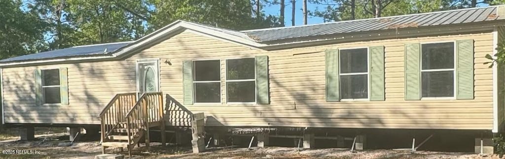 back of house with metal roof